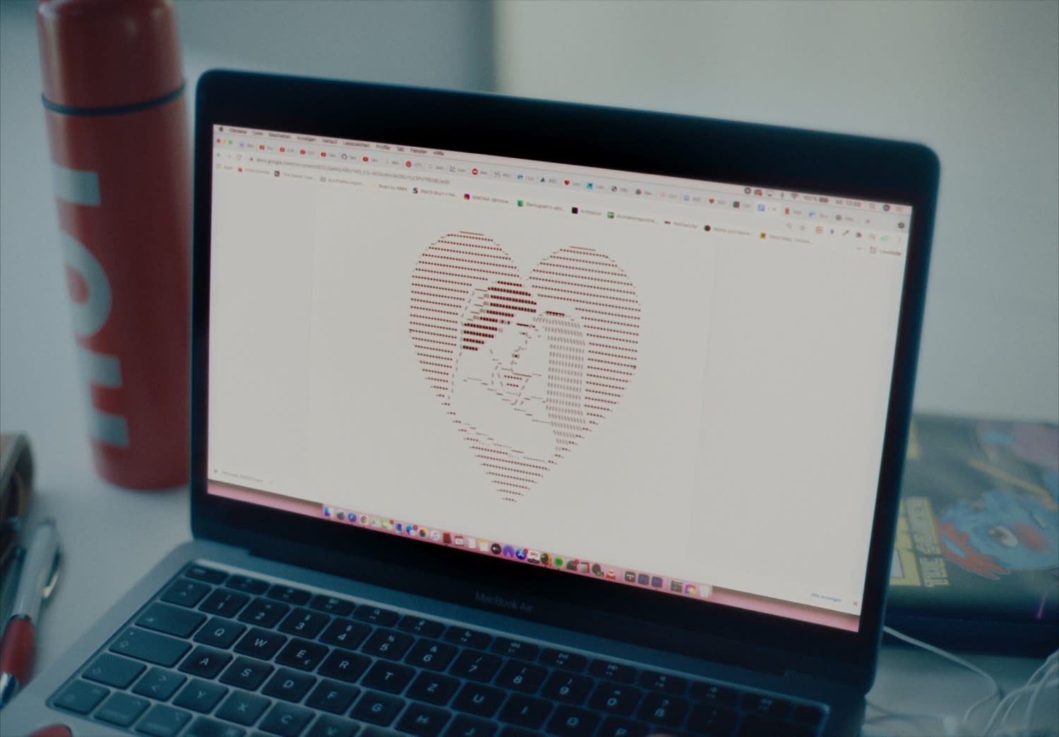 Professionelles color-grading: Laptop zeigt Herz-ASCII-Kunst, warme Farben am modernen Arbeitsplatz.