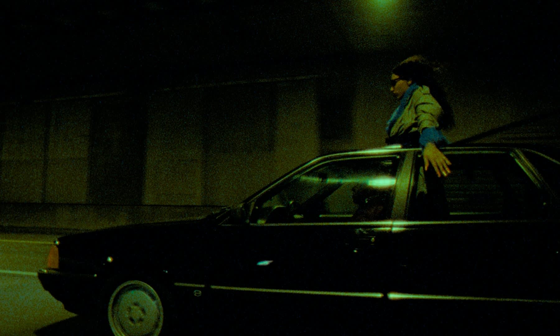 Stimmungsvolle grüne Nachtszene mit Frau im Auto, professionelles Color-Grading für Filmlook.