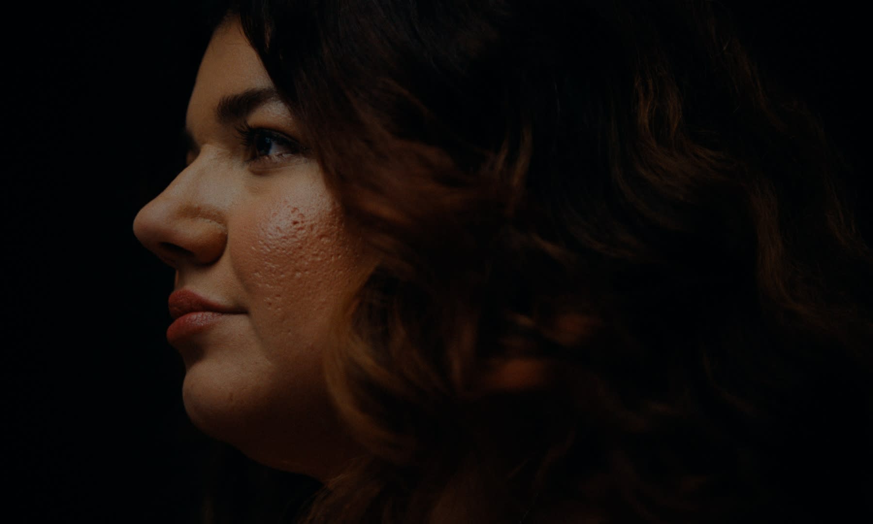 Dunkles, intimes Porträt. Durchdachtes Color-Grading betont emotionale Tiefe und Hauttöne.