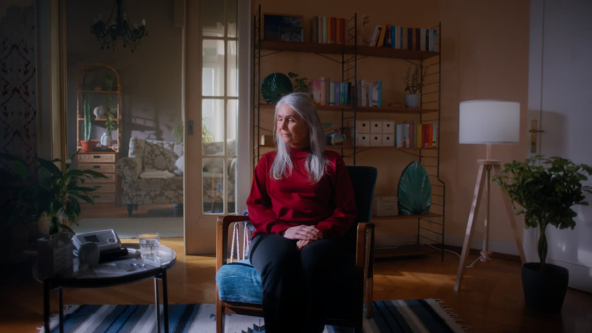 Atmosphärisches Color-Grading einer Seniorin im roten Pullover mit warmem Licht für einen Kinolook.