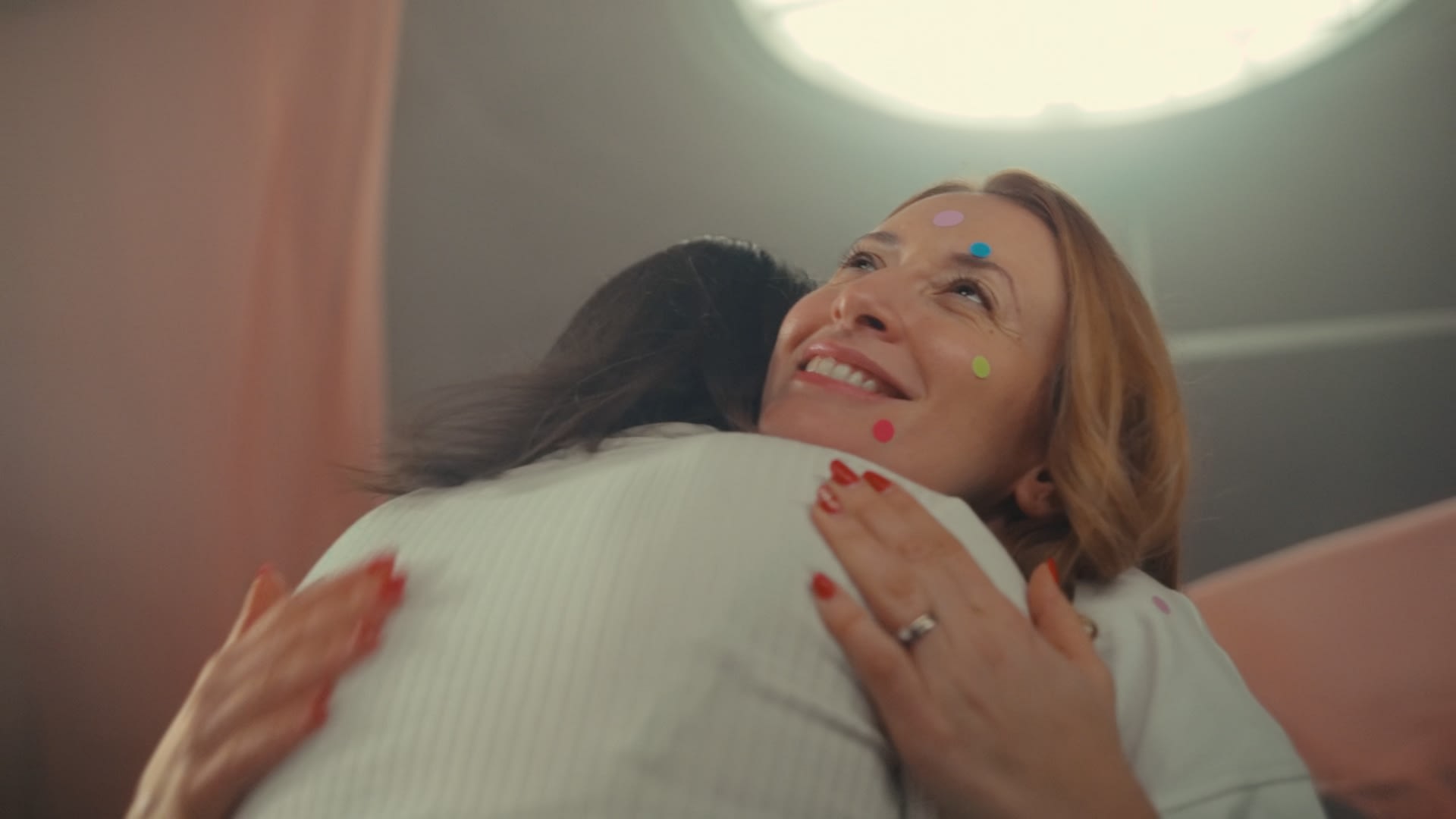 Glückliche Umarmung: Warmes color-grading unterstreicht lachende Gesichter und farbige Details.