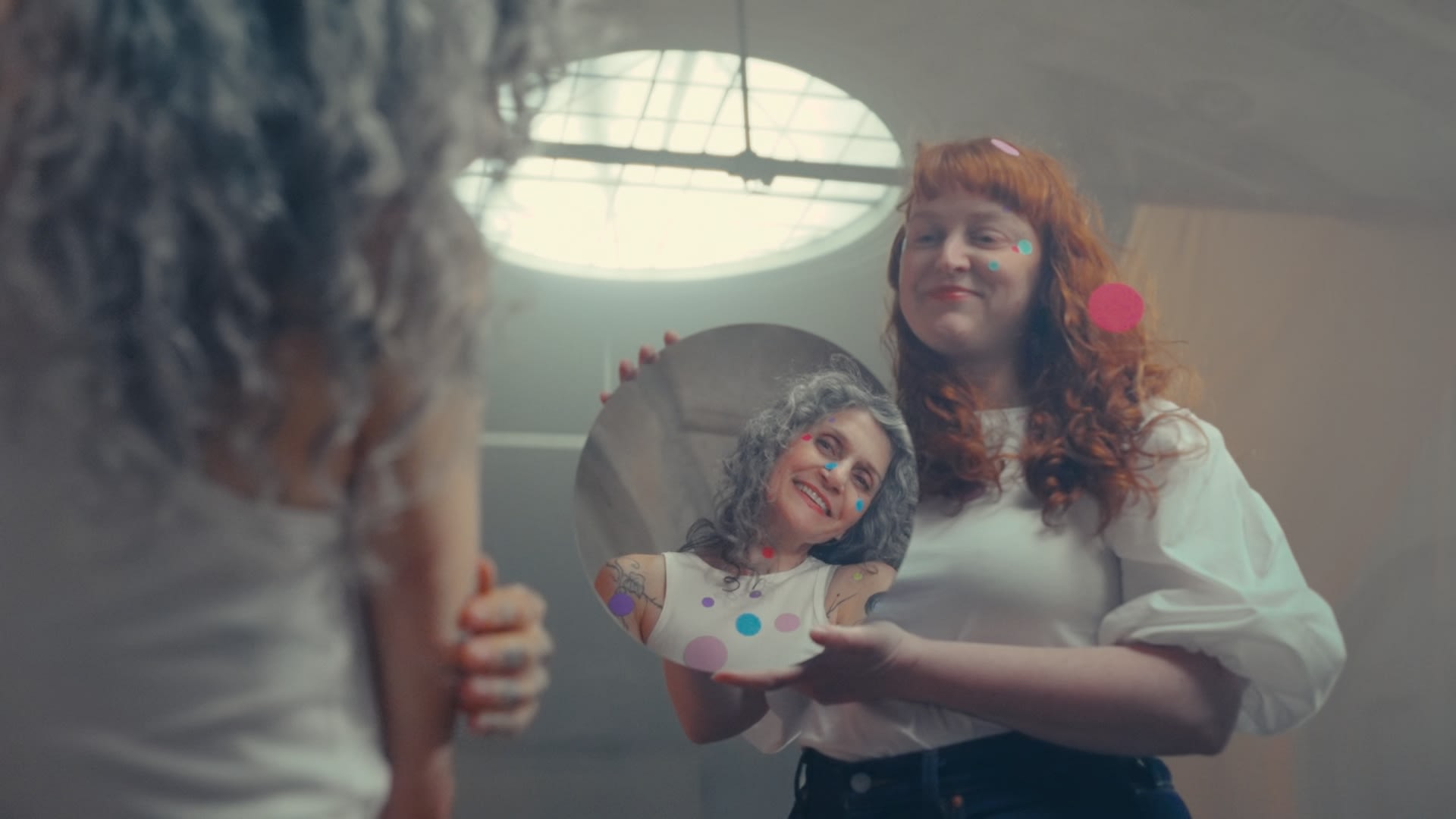 Fröhliche Frauen mit bunten Punkten, kreative Spiegelung, exzellentes Color Grading.