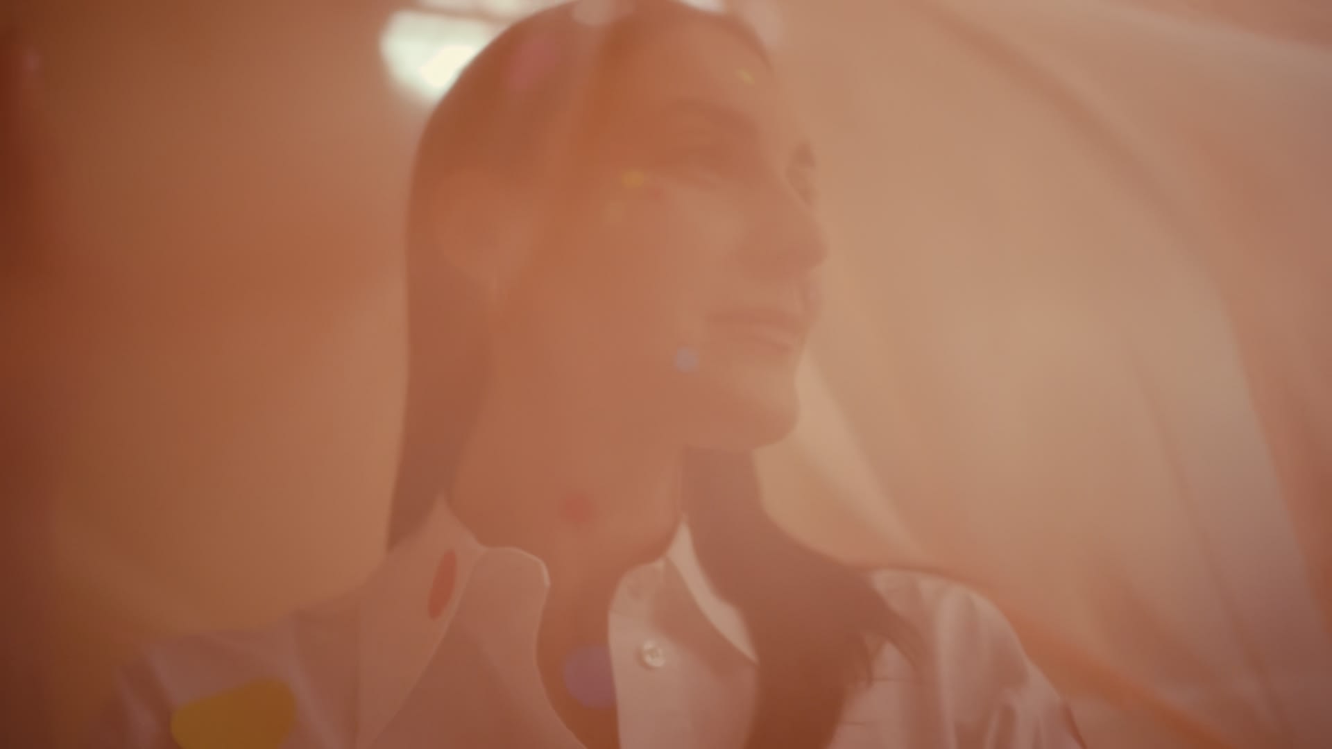 Ätherisches Frauenporträt in warmen Pfirsichtönen mit Bokeh. Gekonntes Color-Grading schafft traumhafte Stimmung.