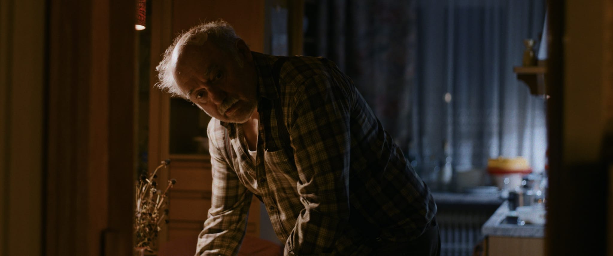 Älterer Mann im karierten Hemd, gedämpfte Farben: Stimmungsvolles color-grading für emotionale Bilder.