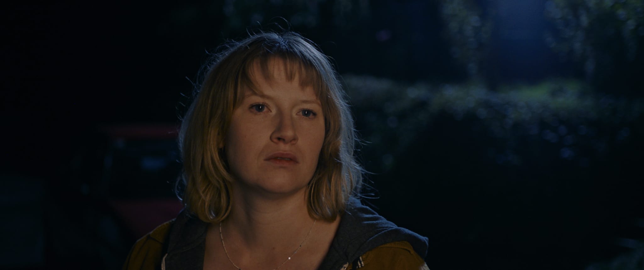 Colorist mit digitalem Grading: Dunkle Stimmung, warme Töne, Frau im Abendlicht.