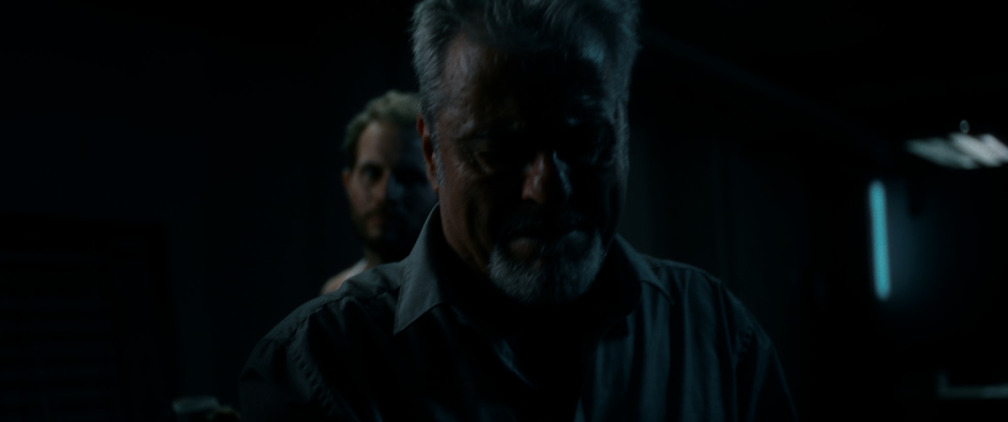 Männlicher Colorist im dunklen Ambiente, stimmungsvolles Grading mit blauen Akzenten.