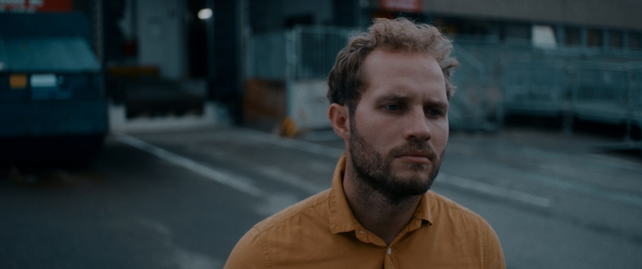 Meisterhaftes color-grading betont nachdenklichen Mann, kühle Farben, warmer Kontrast für filmische Stimmung.