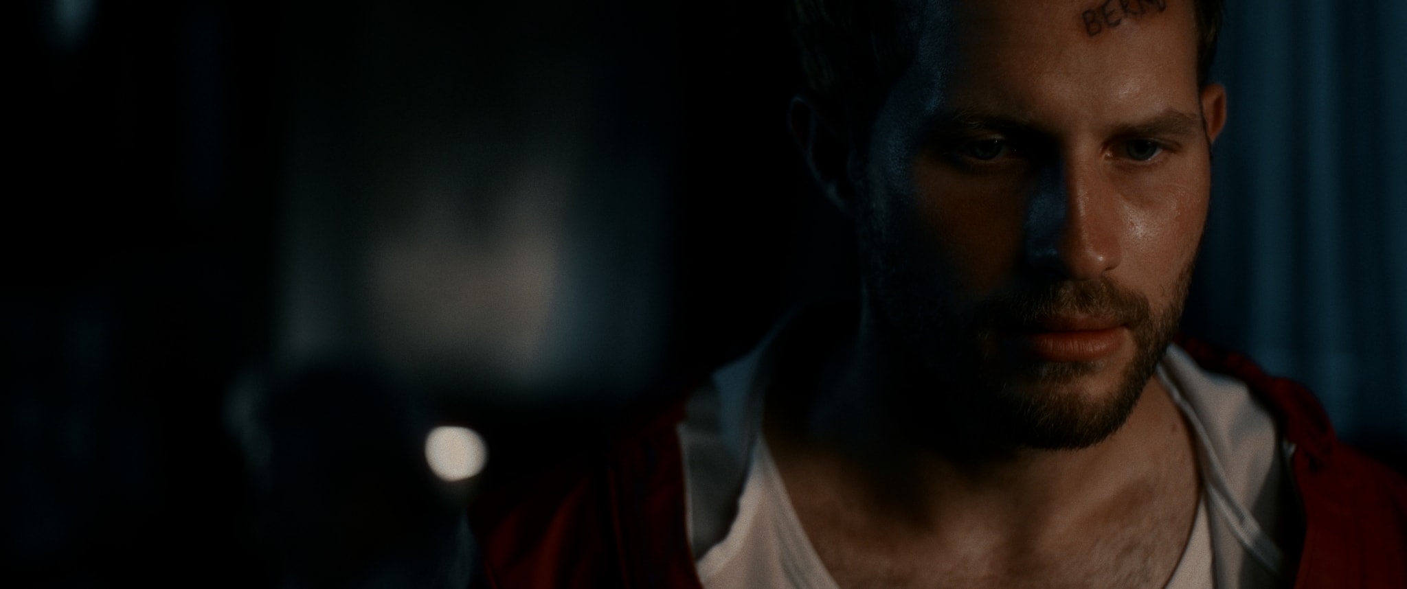 Intensives Männerporträt, ausdrucksstarkes color-grading betont düstere Atmosphäre und Farben.