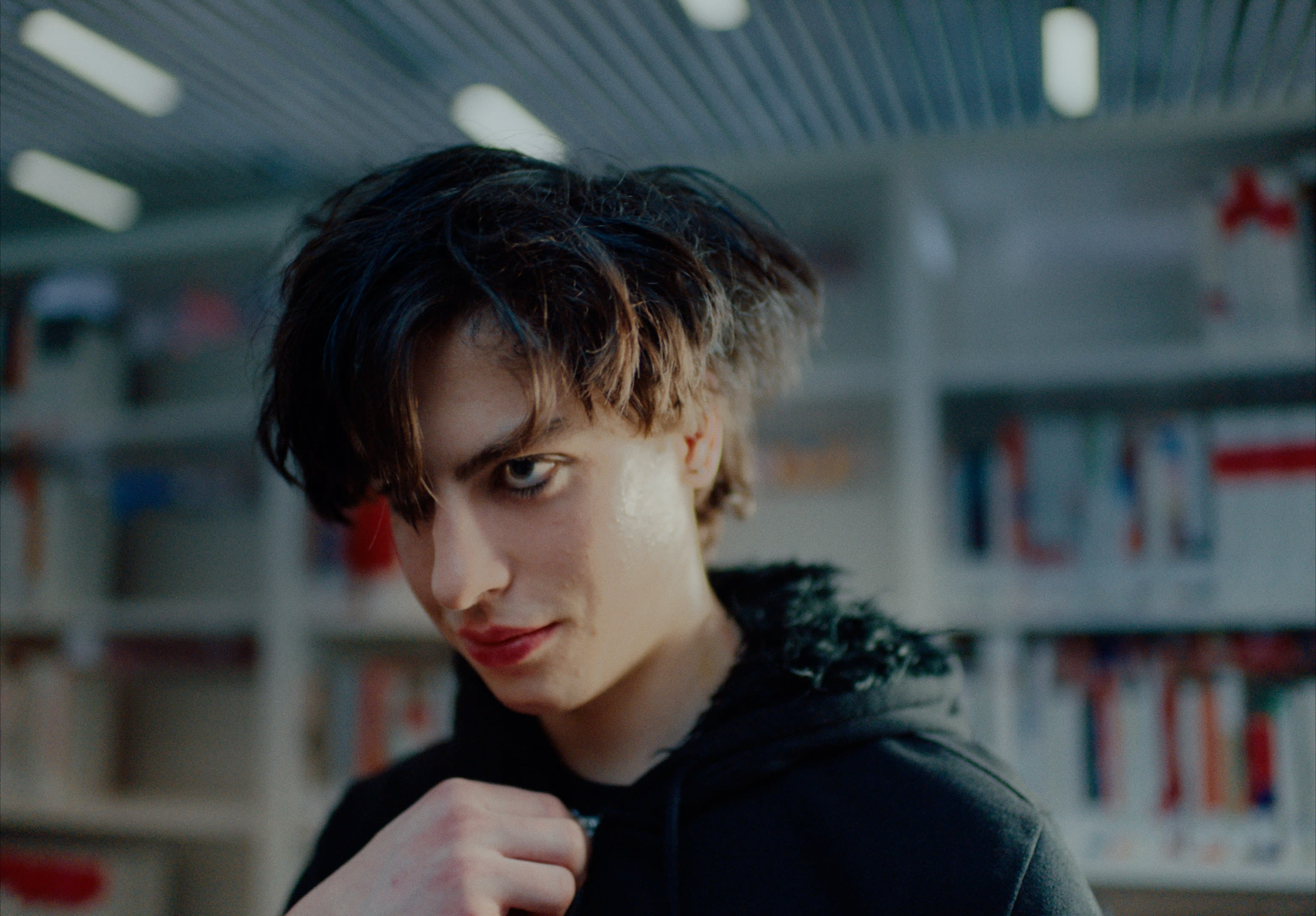 Cooles Color-Grading verstärkt den intensiven Blick eines Jugendlichen in mysteriöser Atmosphäre.