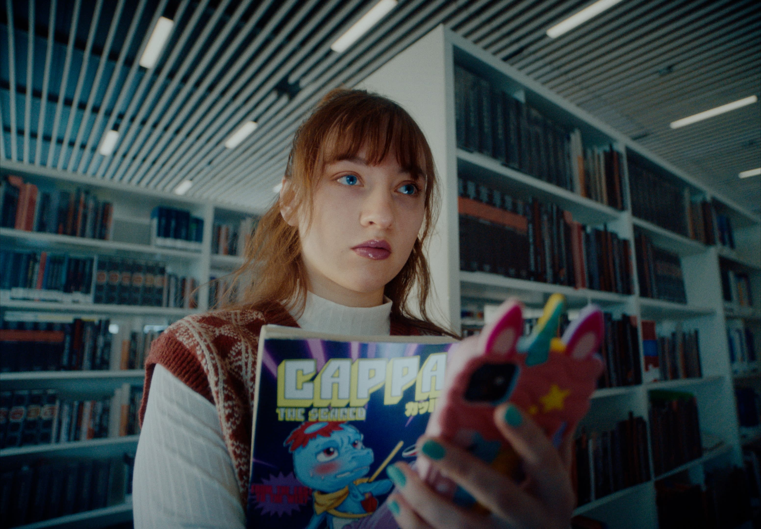 Professionelles Color-Grading unterstreicht blaue Augen und Comic-Kontraste in der Bibliothek.