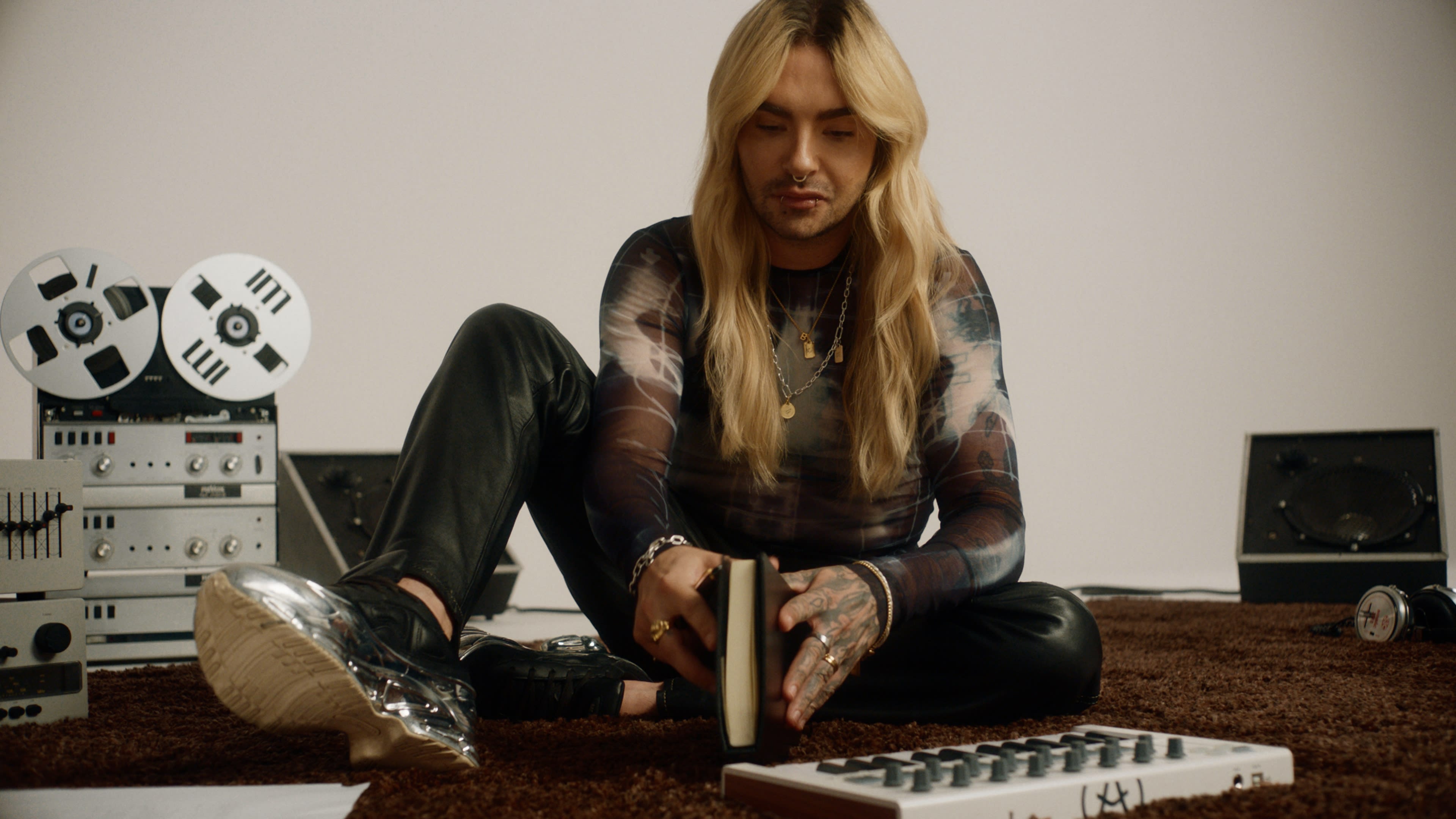 Nachdenklicher Musiker Bill Kaulitz mit Vintage-Geräten; warmer Look eines erfahrenen Coloristen.