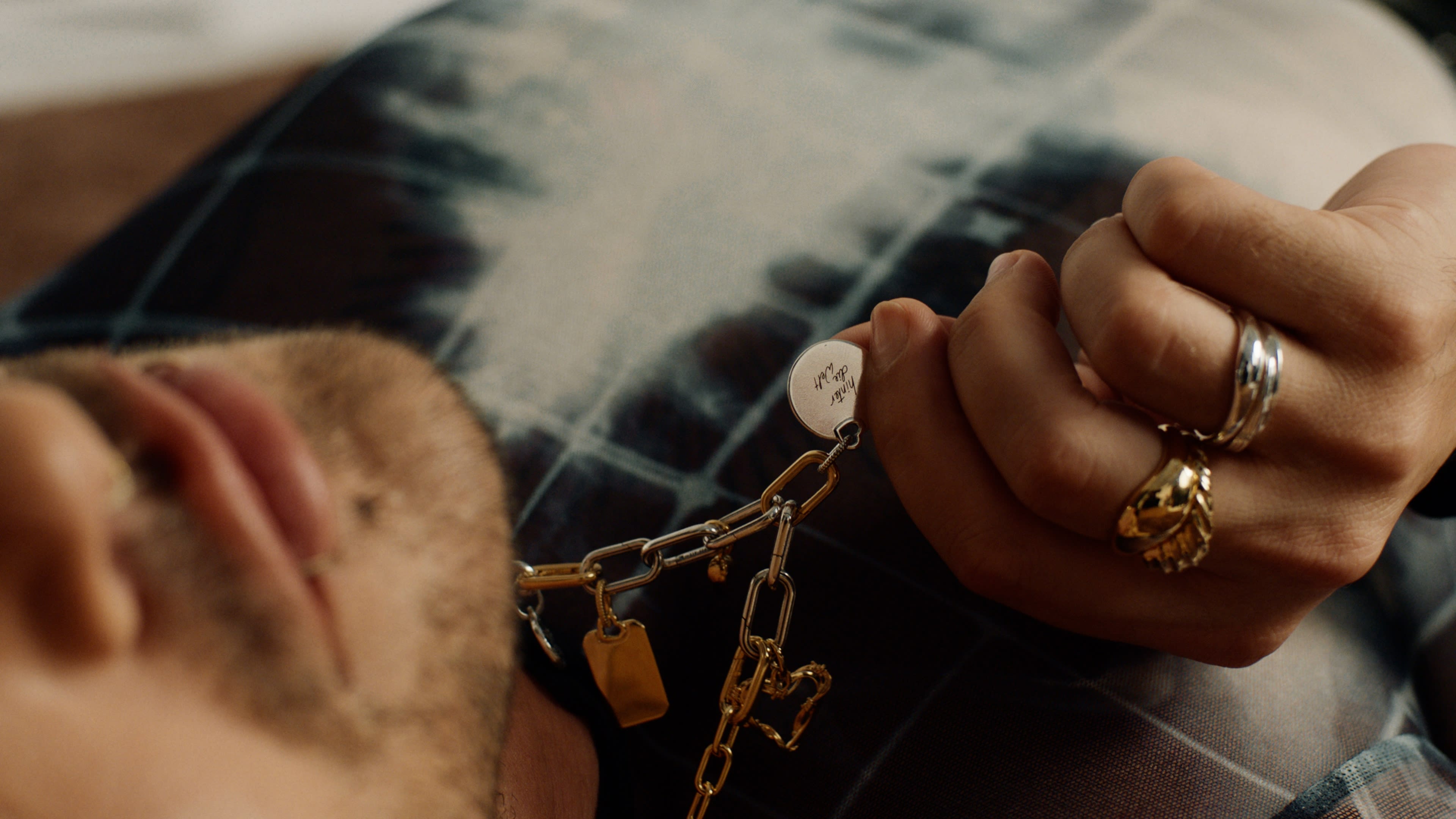 Intimes Porträt, goldenes Schmuckstück in Hand, atmosphärisches color-grading für Wärme.