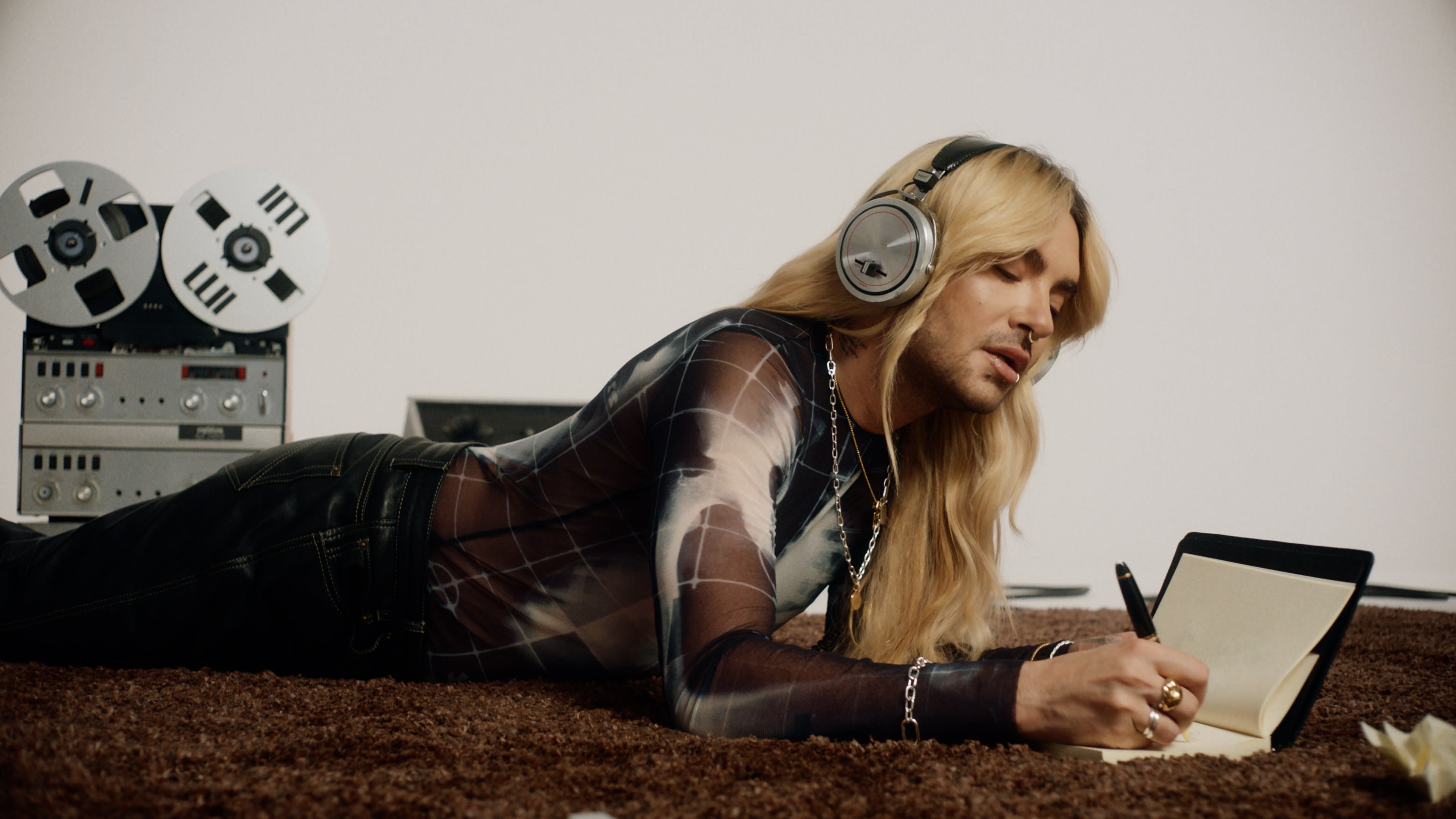 Bill Kaulitz im Studio, Musik hörend, schreibend. Experten-Farbkorrektur schafft warme Stimmung.