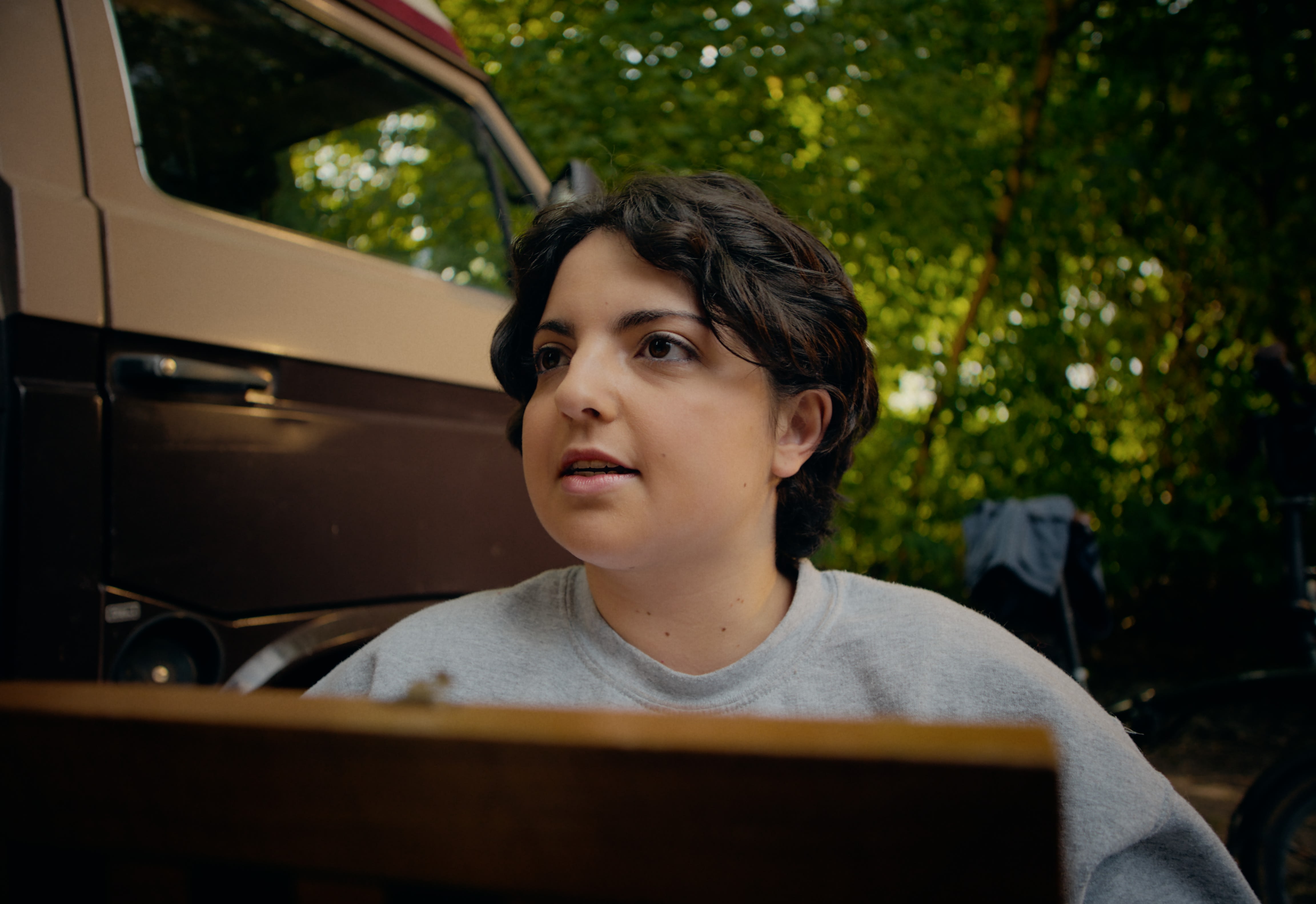 Junge Frau im Freien vor Camper: Professionelles Color-Grading für natürliche, warme Bildstimmung.