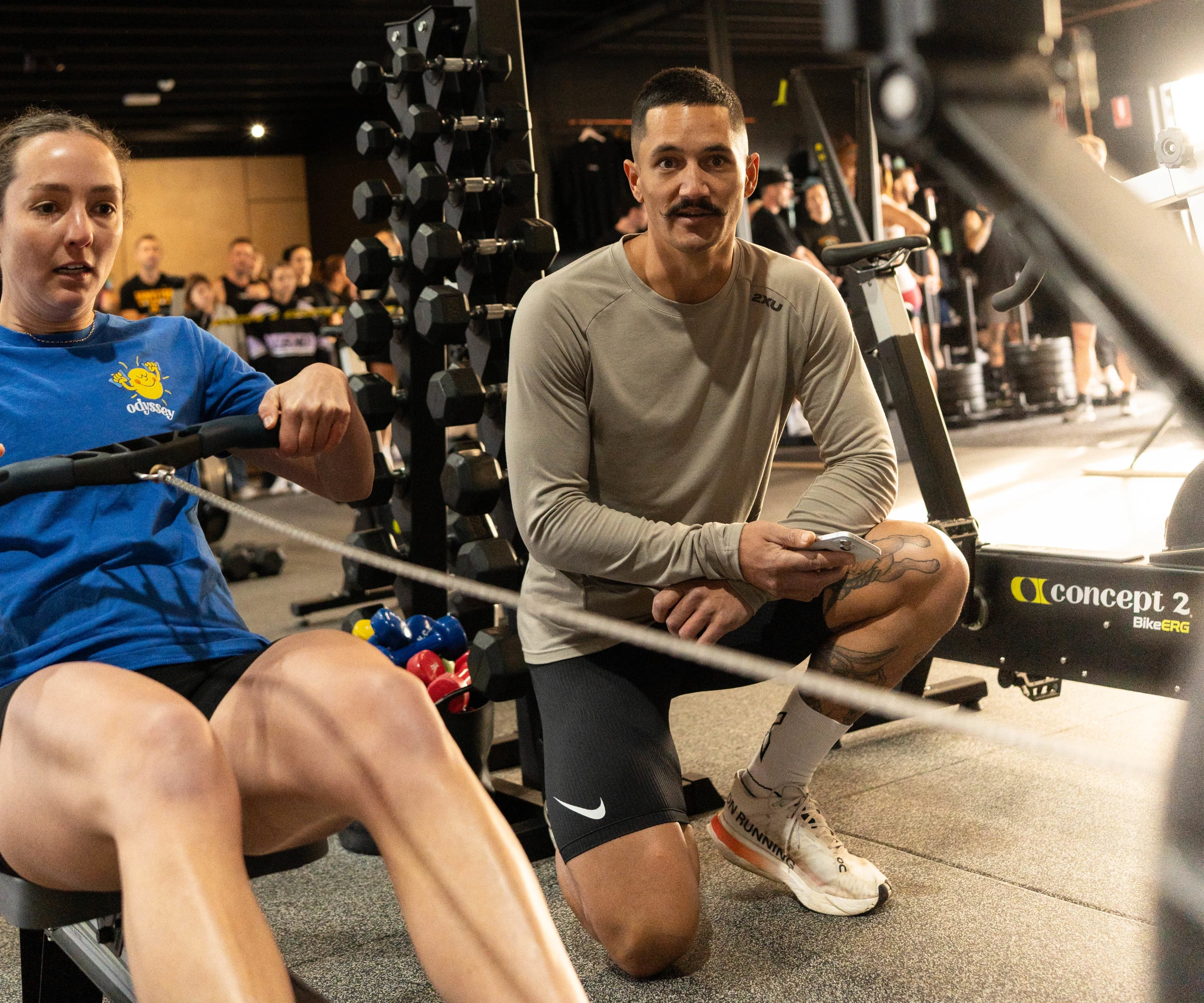 Female on the rower with coach supporting her