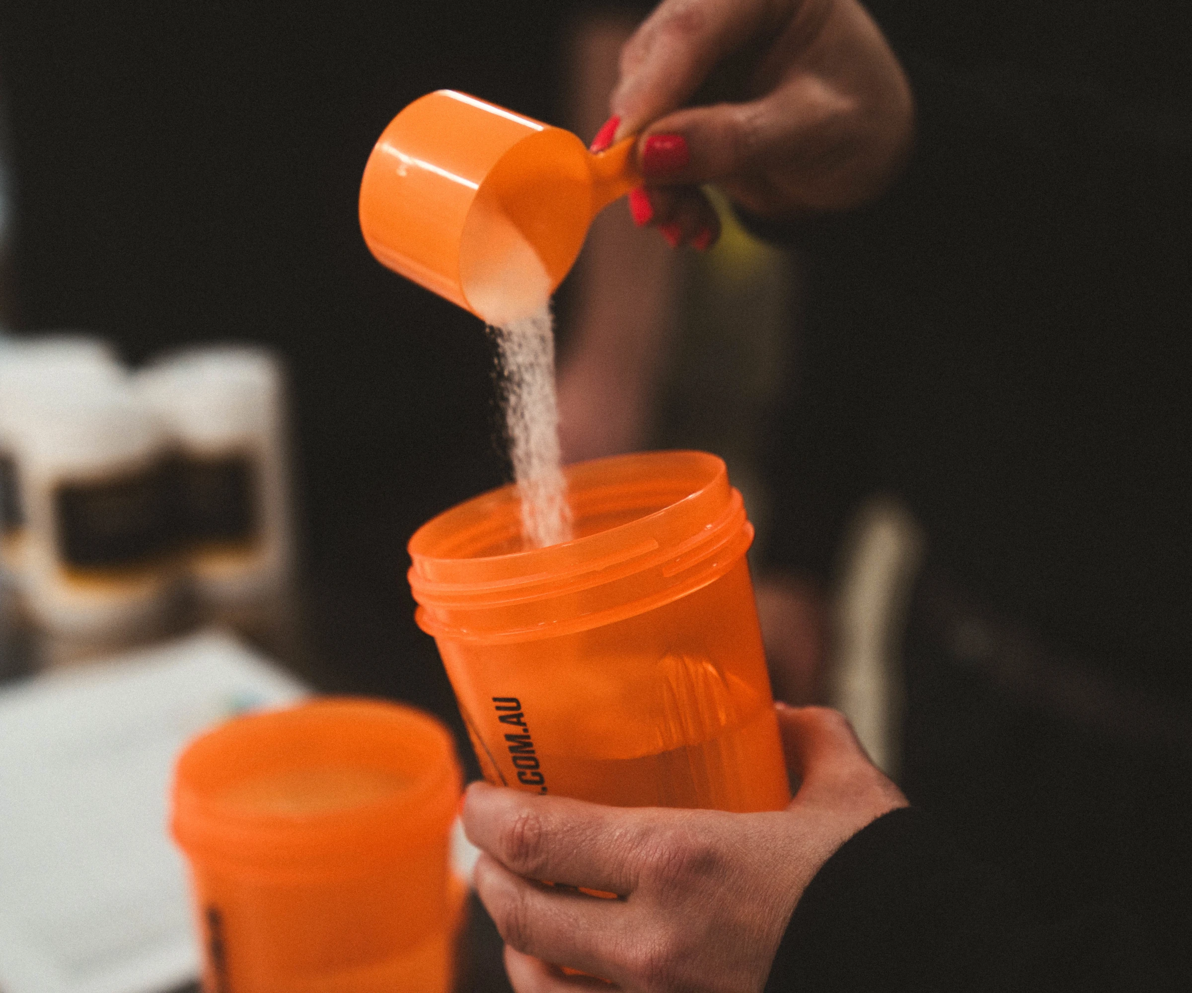 Protein powder being poured into shaker with water
