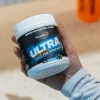 Over the shoulder view of a person holding a tub of Ultra