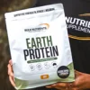 A customer holding a bag of earth protein smiles at the camera.