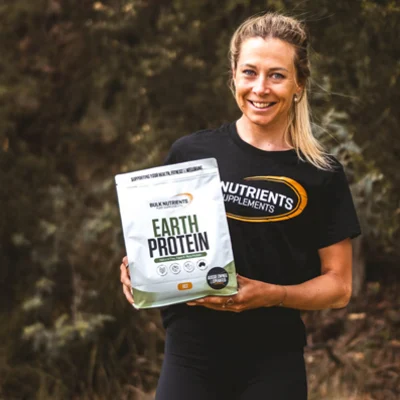 A customer holding a bag of earth protein smiles at the camera.