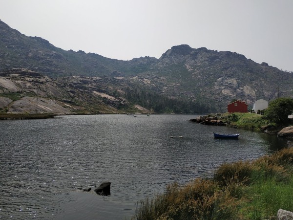 Fotografía de Dumbría que muestra montaña y lago.