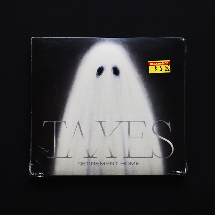 Photo of the CD angled at a distance on a back background. The CD cover has a painting of a ghost on it with the band name somewhat hidden in the fabric of the ghost