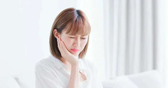 턱 통증이나 치통으로 불편함을 겪고 있는 여성 환자의 모습