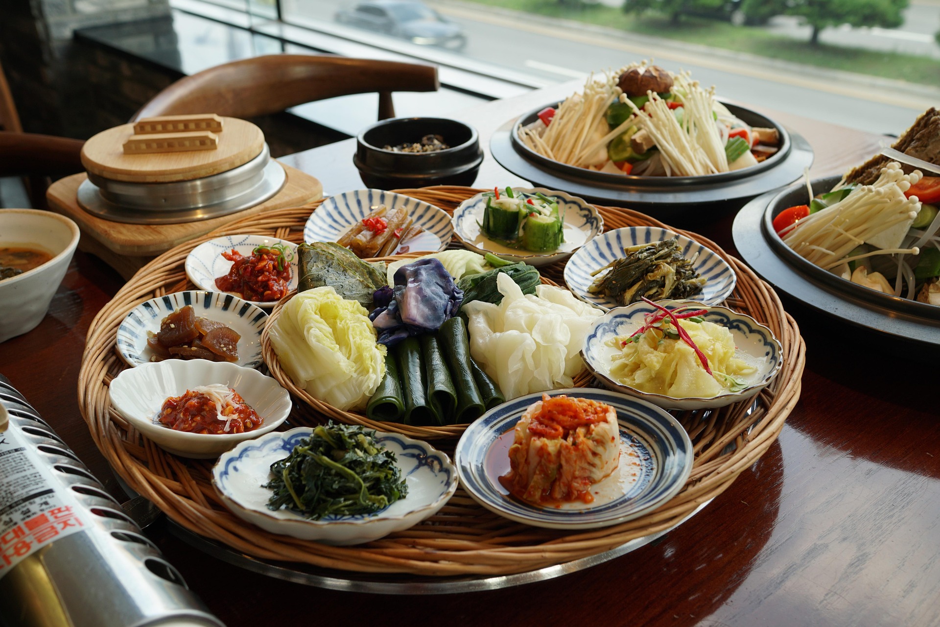 유산균 덩어리 김치, 우리 부모님 건강 수명 늘리는 비법 대공개! 한식 상 위에 김치와 절임·나물 등 다양한 발효 반찬이 담긴 큰 쟁반 — 유산균 풍부한 김치로 부모님 장건강과 식탁 건강을 챙기는 이미지