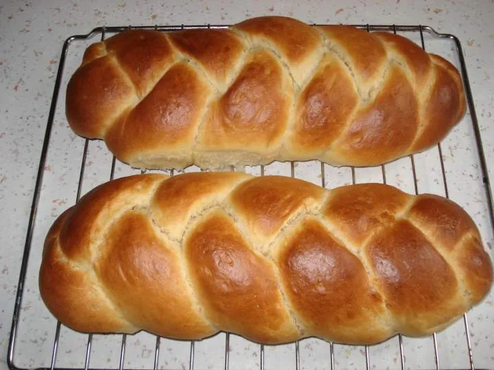 식힘망 위에 올려진 꼬아 만든 브리오슈 식빵 두 덩이—프랑스 왕실의 빵, 버터가 만든 황금빛 크러스트와 촉촉한 결