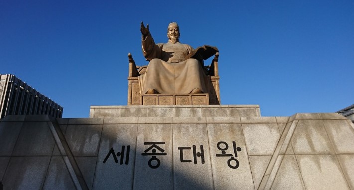광화문 광장에 설치된 세종대왕 동상을 정면에서 담은 사진으로, ‘세종대왕의 유언’ 주제를 해설하는 글에 어울리는 상징 이미지입니다.