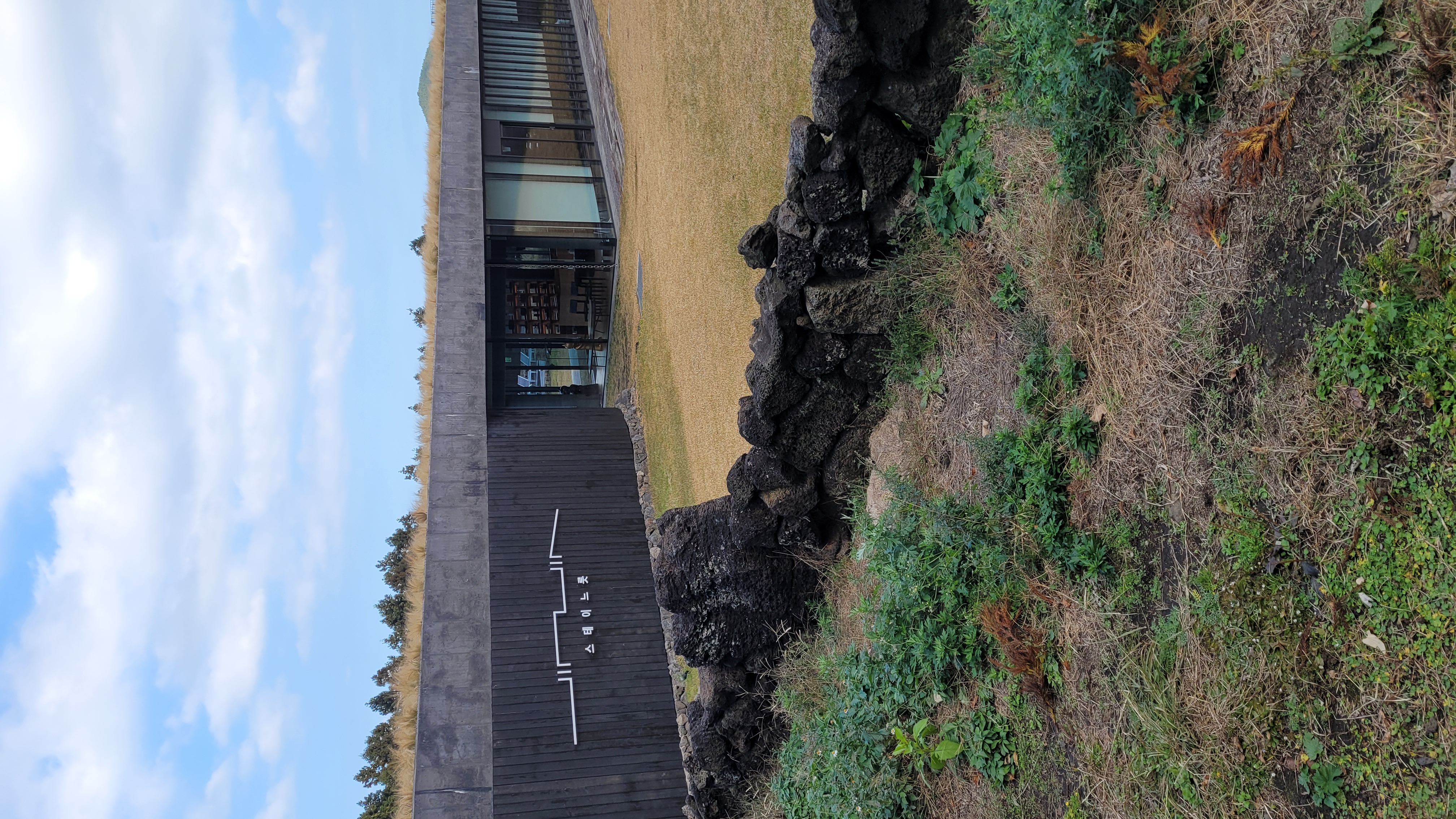 제주 보롬왓 스테이노츠 건물, 콘크리트와 검은 목재가 조화를 이룬 모던한 건축물과 현무암 돌담