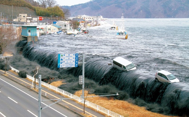 2011년 동일본대지진 쓰나미가 일본 해안 도시를 덮치는 순간 - 거대한 지진해일이 방파제를 넘어 차량과 건물을 집어삼키는 장면