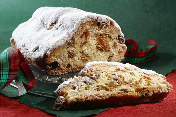 설탕가루가 뿌려진 독일 전통 크리스마스 슈톨렌 빵과 단면이 보이는 모습, 건과일과 견과류가 가득 들어있음