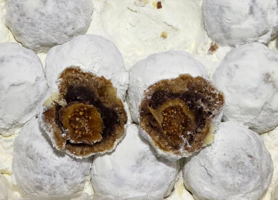 설탕가루로 덮인 학화 슈톨렌 호두과자의 단면, 무화과와 건과일이 가득 들어있는 속이 보이는 모습