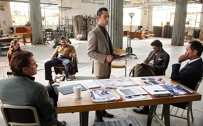 인셉션 코브와 팀원들이 창고에서 작전을 계획하는 장면으로, 꿈속 임무 설계 과정을 보여주는 스틸컷