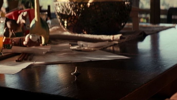 인셉션 마지막 장면에서 테이블 위에 팽이가 멈추지 않고 계속 돌아가는 결말 스틸컷으로 현실인지 꿈인지 해석이 엇갈리는 핵심 장면