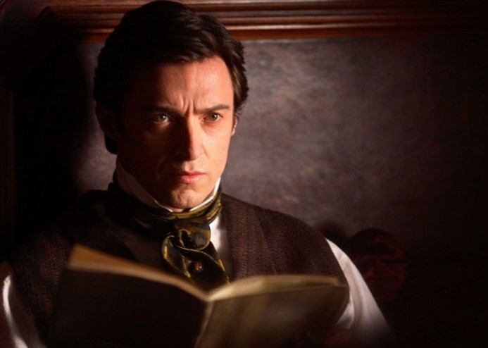 영화 프레스티지 스틸컷 – 로버트 앤지어가 어두운 조명 아래 일기장을 읽으며 집착과 복수를 계획하는 장면