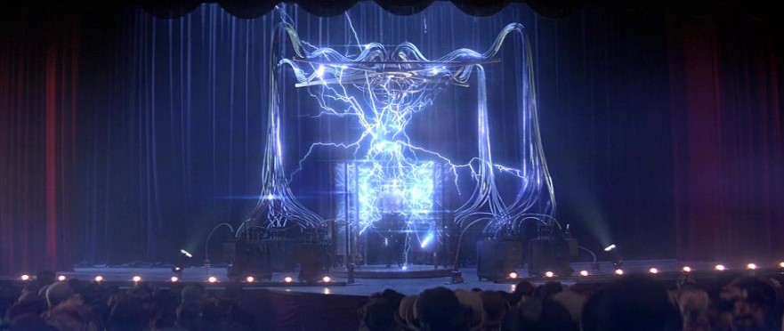 영화 프레스티지 스틸컷 – 무대 위에서 테슬라의 순간이동 장치가 강렬한 번개를 내뿜으며 작동하는 마술 공연 장면