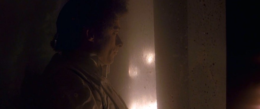 영화 프레스티지 결말 스틸컷 – 어둠 속에서 빛을 향해 홀로 서 있는 앤지어의 측면 모습, 충격적인 마지막 장면