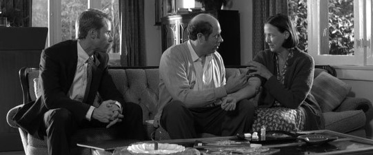 메멘토 영화 흑백 스틸컷 - 레너드가 기억 속에서 만들어낸 가공인물 새미 젠킨스 부부와 함께 앉아 있는 과거 회상 장면, 핵심 반전 포인트