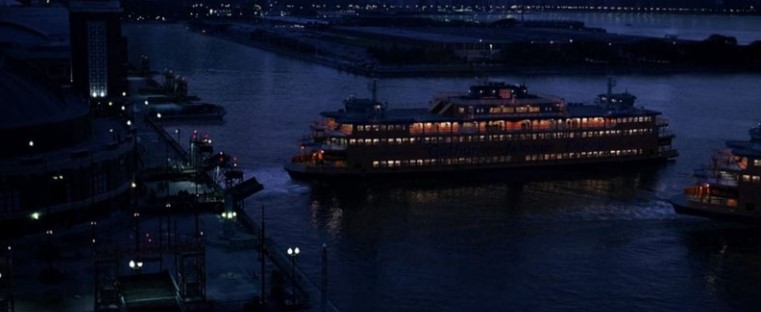다크 나이트 배 위 사회실험 장면 - 야간 강 위에 불빛이 켜진 대형 여객선이 떠 있는 모습. 조커가 시민들과 죄수들을 각각 태운 두 척의 배에 폭탄을 설치하고 서로의 기폭장치를 맞바꿔주는 잔혹한 사회실험이 벌어지는 핵심 장면