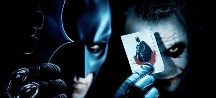 다크 나이트 배트맨과 조커 좌우 대칭 포스터 - 왼쪽의 배트맨과 오른쪽의 조커가 얼굴을 맞댄 구도로, 조커가 배트맨이 그려진 조커 카드를 눈앞에 치켜들고 있는 장면. 서로가 서로를 완성시키는 동전의 양면 관계를 가장 상징적으로 표현한 다크 나이트 대표 포스터 이미지