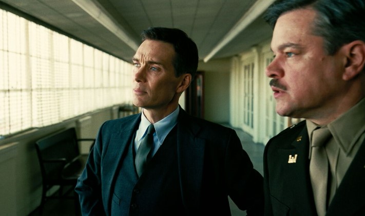 오펜하이머 결말 해석 - 오펜하이머와 레슬리 그로브스 장군이 복도에서 나란히 서서 앞을 응시하는 맨해튼 프로젝트 장면