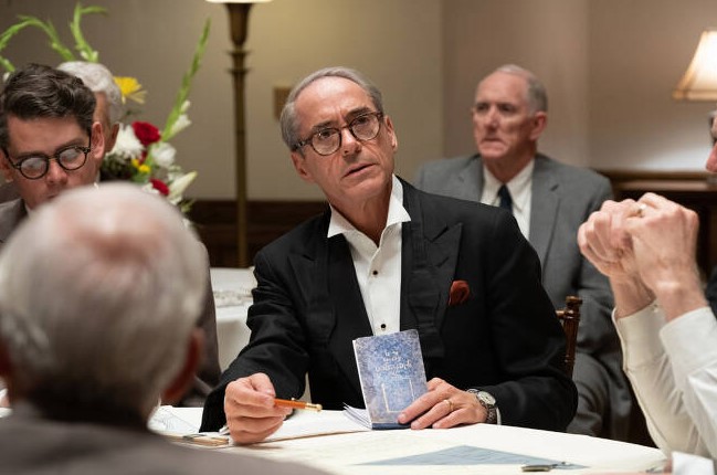 오펜하이머 결말 해석 - 로버트 다우니 주니어가 연기한 스트로스가 만찬 자리에서 날카로운 눈빛으로 앉아 있는 장면