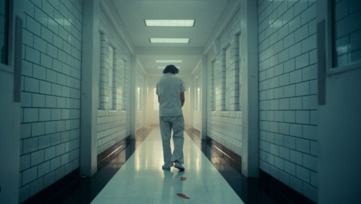 영화 조커(2019) 결말 장면에서 아캄 정신병원 환자복 차림의 아서 플렉이 흰 복도에 핏자국을 남기며 홀로 걸어가는 마지막 장면