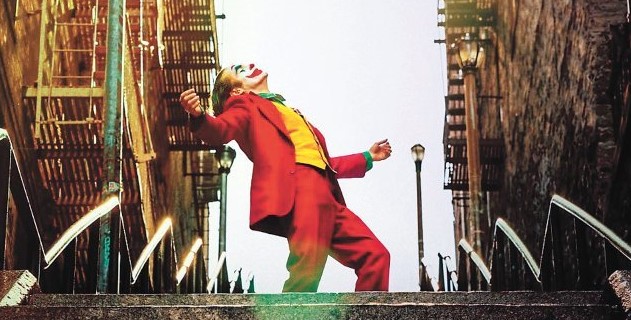 영화 조커(2019) 호아킨 피닉스가 붉은 정장 차림으로 브롱크스 계단 위에서 온몸을 하늘을 향해 활짝 젖히며 춤추는 장면으로 사회적 억압으로부터 완전한 해방을 상징하는 조커의 대표 명장면