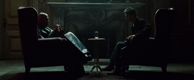 매트릭스에서 어두운 방 안 두 개의 안락의자에 마주 앉아 대화를 나누는 모피어스와 네오, 테이블 위 빨간약과 파란약이 놓인 상징적인 장면