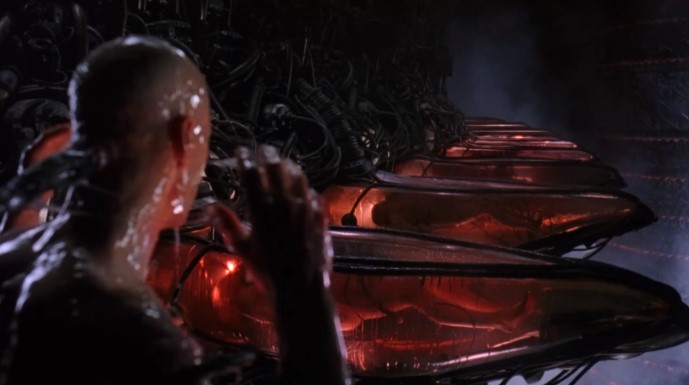 매트릭스에서 네오가 빨간약을 먹은 후 눈을 뜬 현실 세계, 붉은빛 액체로 가득 찬 캡슐 속에 인간들이 배터리처럼 사육되고 있는 충격적인 진실의 장면