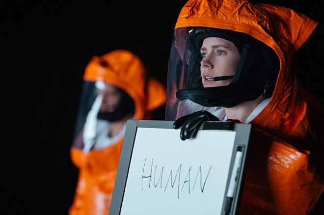컨택트 Arrival 루이스가 방호복을 입고 HUMAN이라고 쓴 보드를 들어 헵타포드와 첫 소통을 시도하는 장면