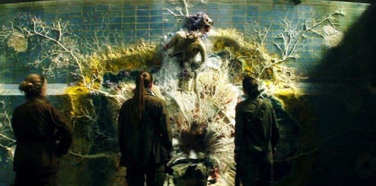 애니힐레이션 쉬머 내부 장면 - 식물로 변한 인간 형태 앞에 선 탐사대원들