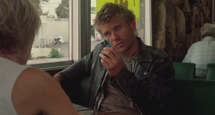 영화 멀홀랜드 드라이브 후반부 현실 장면. 윙키스 식당에서 킬러가 다이앤에게 살인 의뢰의 완성을 의미하는 파란 열쇠를 보여주는 모습. 결말 해석의 핵심적인 복선.